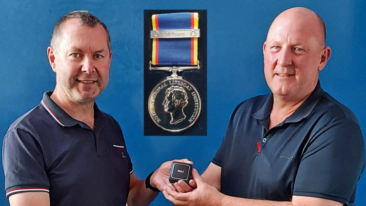 Chris Sims, left, receiving award from Deputy Coxswain Roger Jackson (John Thorogood/ RNLI)