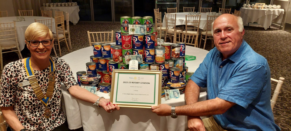President Carol and Past President Huw, with the Rotary International Citation sat in front of 48Kgs of food collected that night from members for local Food Banks.