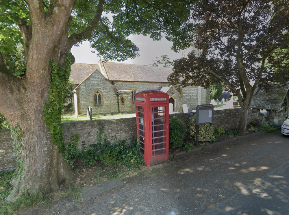 The traditional red phone box  outside the church in Stratton, near Dorchester (photo credit: Google Maps)