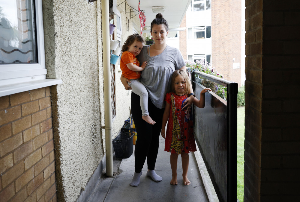 Emelyne Offin, 28, with her two daughters on the Ham Close estate. (Photo: Facundo Arrizabalaga/MyLondon)