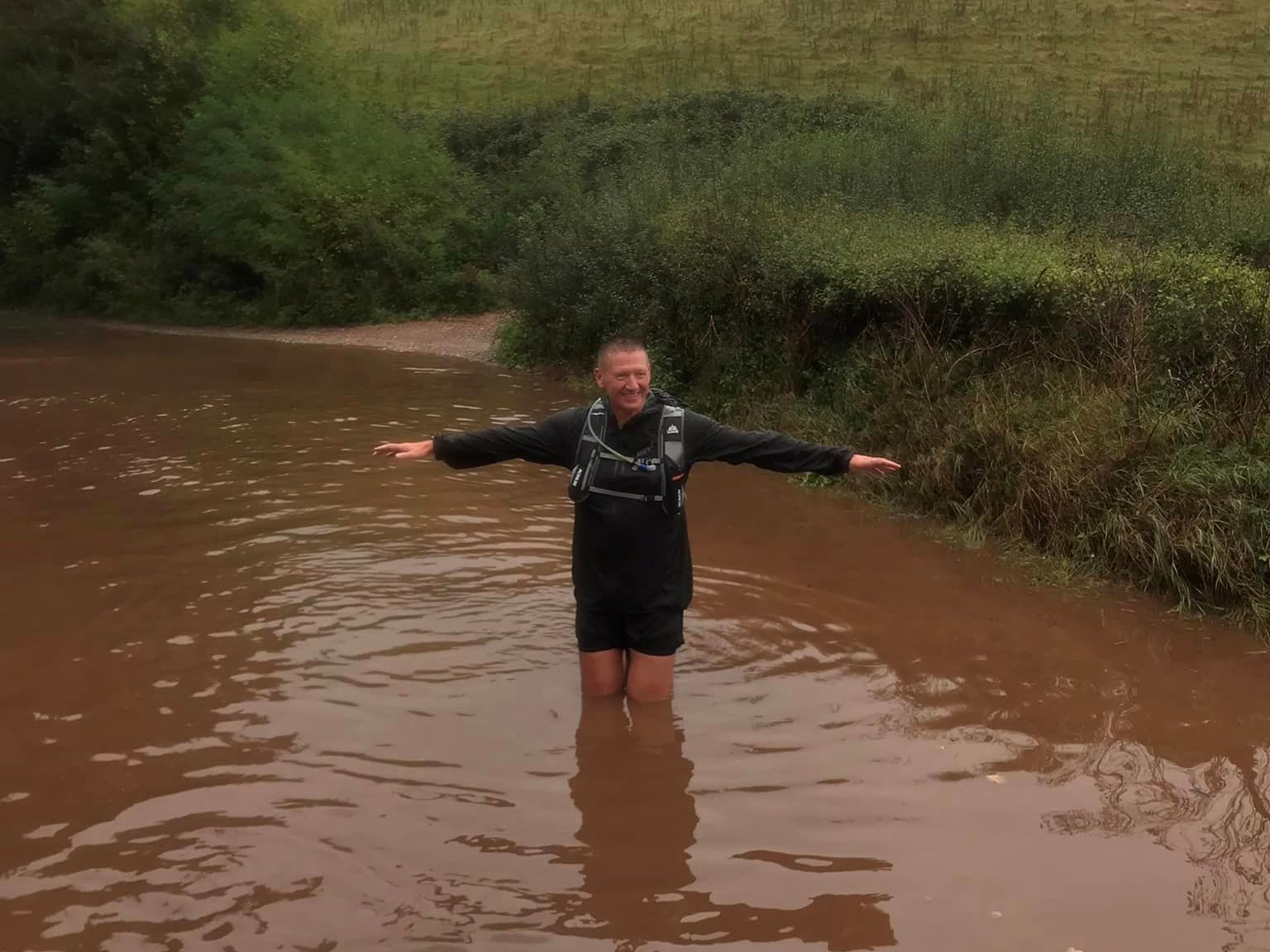 Richard King thigh high in flood water