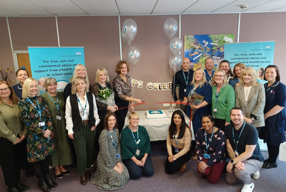 Colleagues gather to celebrate the launch of the Healthy Together Helpline, with director of families, young people, children, learning disability and autism services at Leicestershire Partnership NHS Trust, Helen Thompson (centre), cutting a ribbon to mark the occasion. Image credit: LPT.