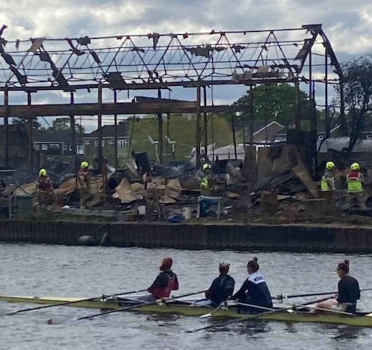 Rowers and firefighters survey the wreckage from the fire last night