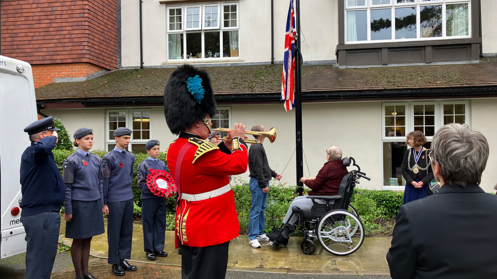 Bugler Vic Gilder plays while Army veteran Bob raises the Union Flag outside Surbiton veteran care home. (Photo: Royal Star & Garter)