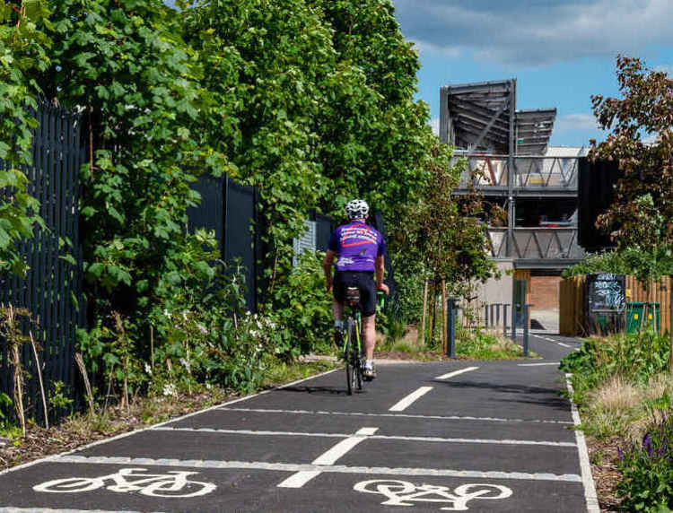 A cyclist in Kingston on the new cycle lane connecting the station and the riverside (Credit: Ollie Monk)