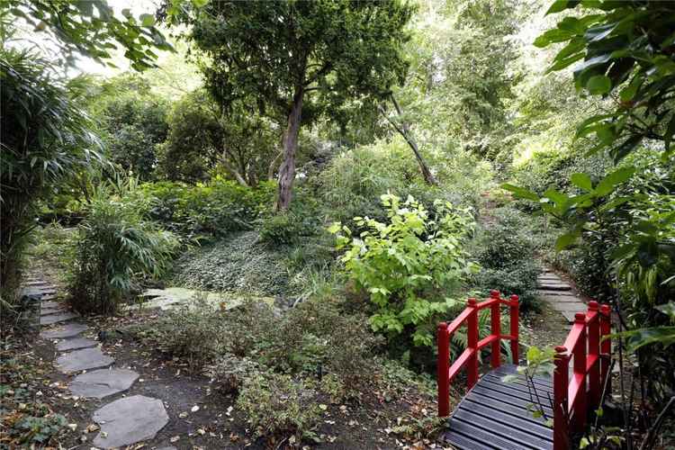 The development's landscaped gardens include stepping stones and a Japanese-style bridge (Credit: Savills Wimbledon via Rightmove)