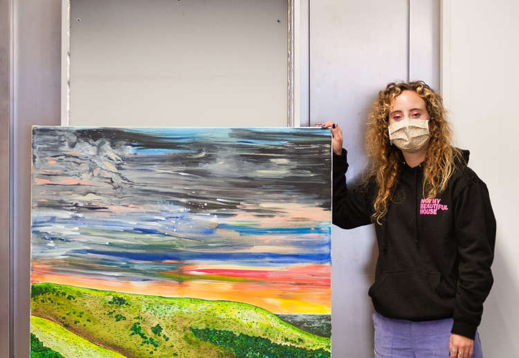 Imogen Ashby with her painting at Not My Beautiful House (Credit: Ollie G Monk)