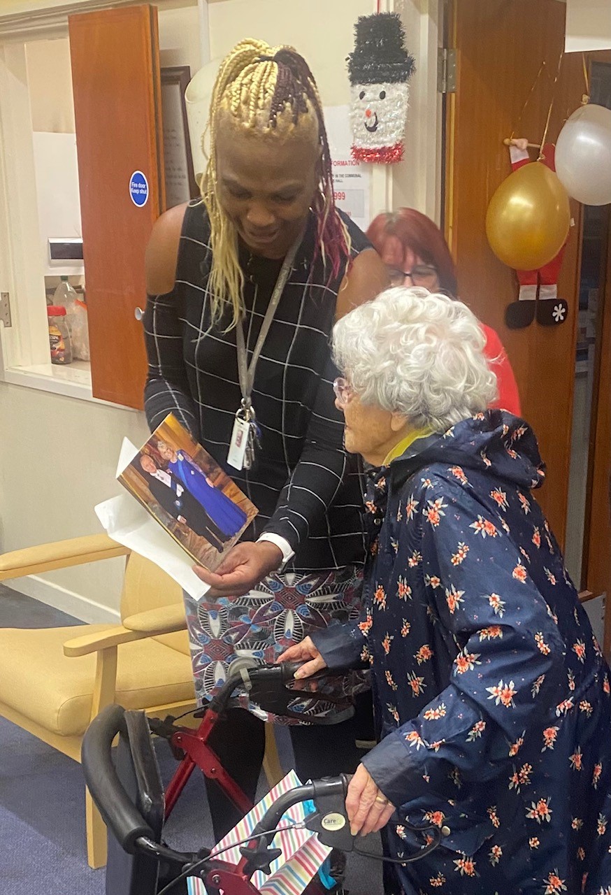 Mary shows sheltered housing manager Sam Edward her card from the King. 