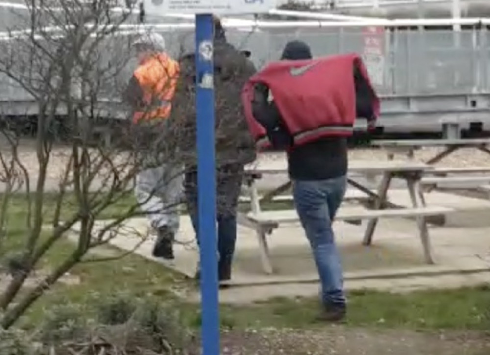 Balcovei, in hi-viz, was pictured leading migrants away at Thurrock Services. 