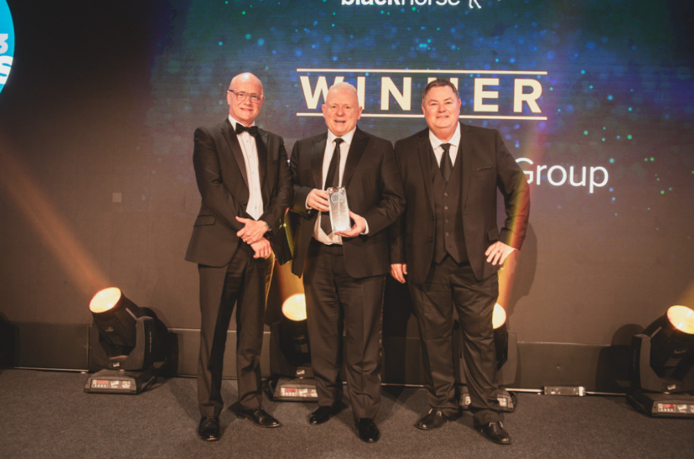 Swansway Director Peter Smyth, centre, collects his trophy from Tim Smith, left, head of UCA headline sponsors Black Horse Motor Finance, and awards night compere Mike Brewer (Image - Swansway)