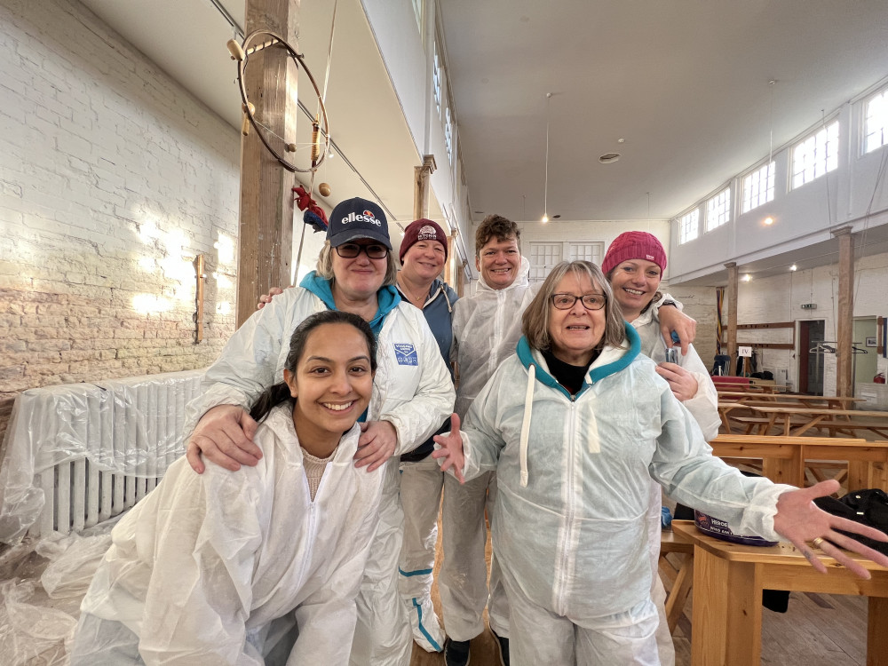 Kind-hearted volunteers from Raymond James take a quick break from painting the British Schools Museum. CREDIT: Hitchin Nub News 