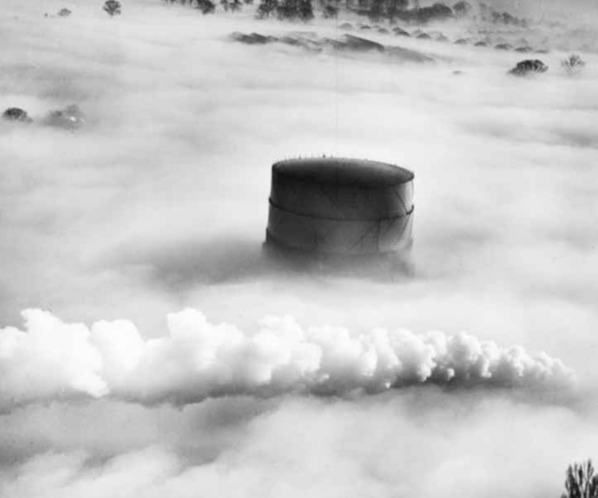 Stunning: Hitchin gasometer and the plume from a passing steam locomotive under fog taken in 1949