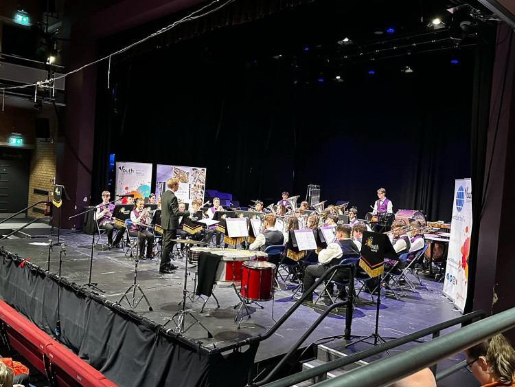 Director Ian Raisbeck on stage with the band. (Photo: Lions Youth Band)