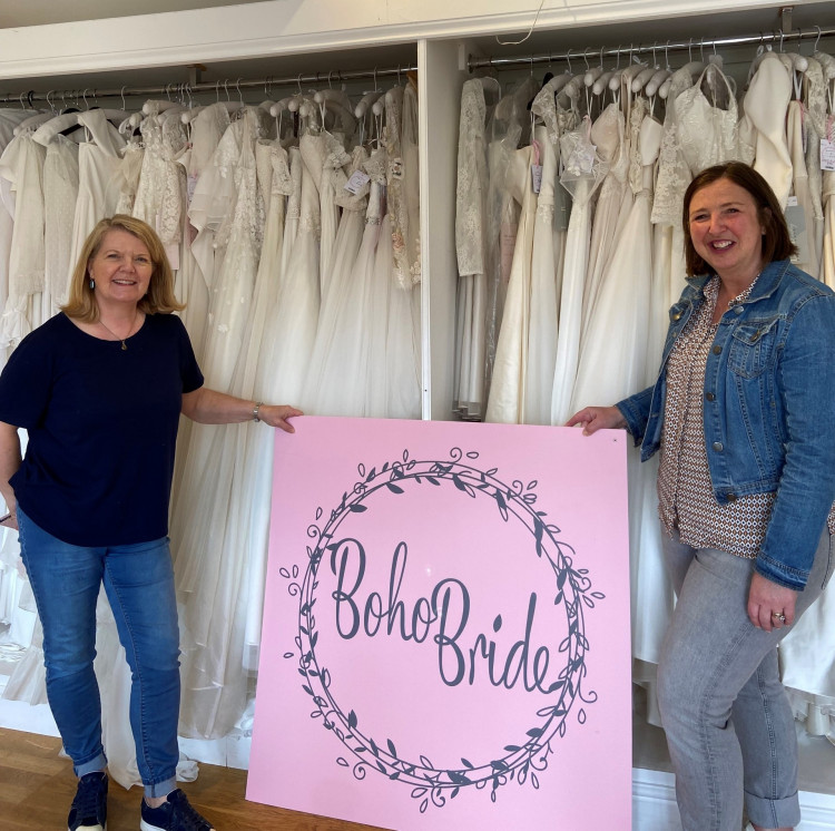 Lynette Turner of Boho Brides hands over the wedding dresses to Rachel Ollerenshaw of Molly Ollys (image supplied)