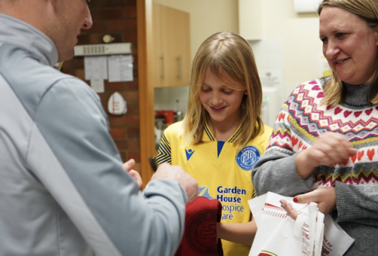 Charlotte with her son receiving gifts from Stevenage FC wearing the club's third kit that will be worn by the players on Saturday. CREDIT: SFC/GHHC