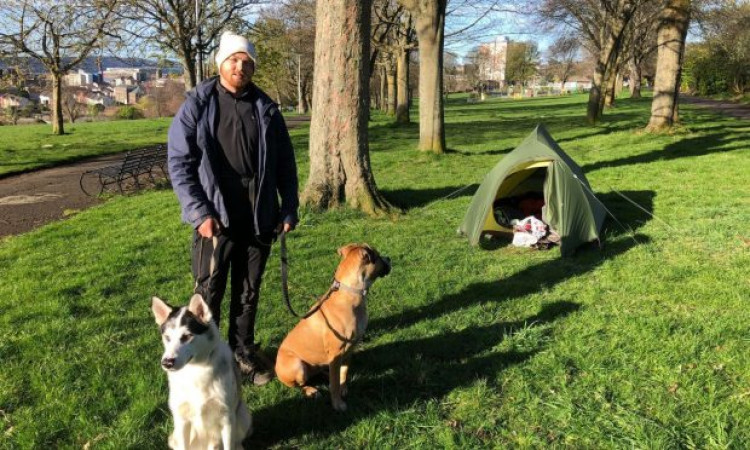 Jordan Kealey with dogs Jackson and Shyla at his makeshift campsite in Dudhope Park in Dundee on Tuesday. Image: James Simpson/DC Thomson