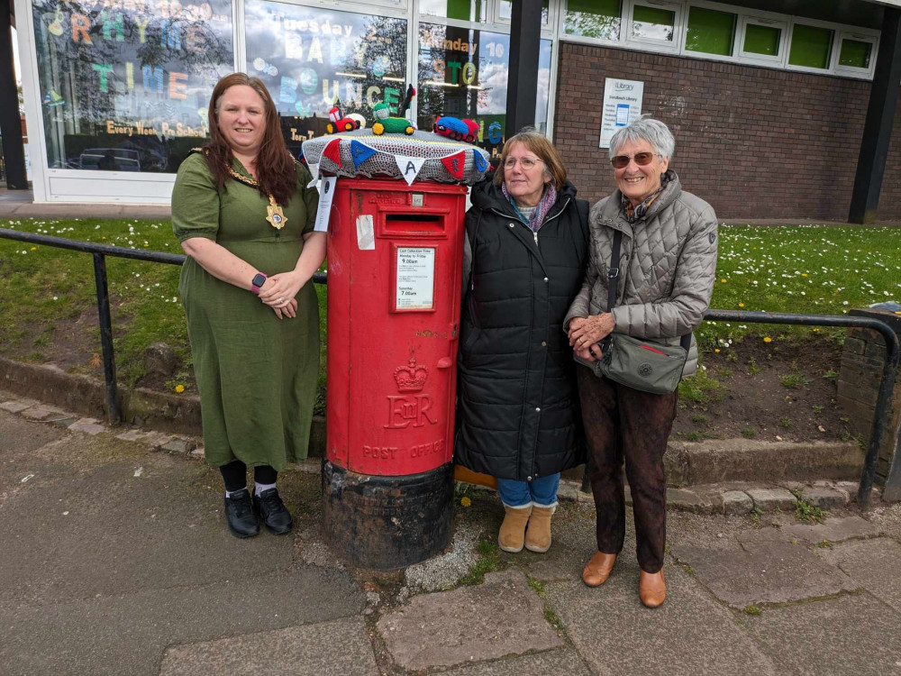 Members of the group placed the topper on the post box. (Photo: Nub News) 