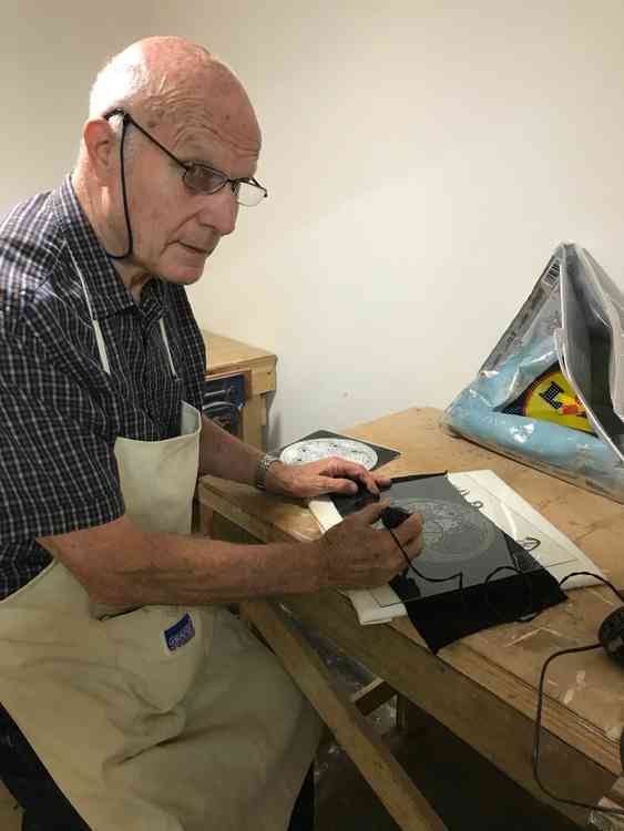 Retired police officer Ian Allan working on an intricate glass engraving project for his home.