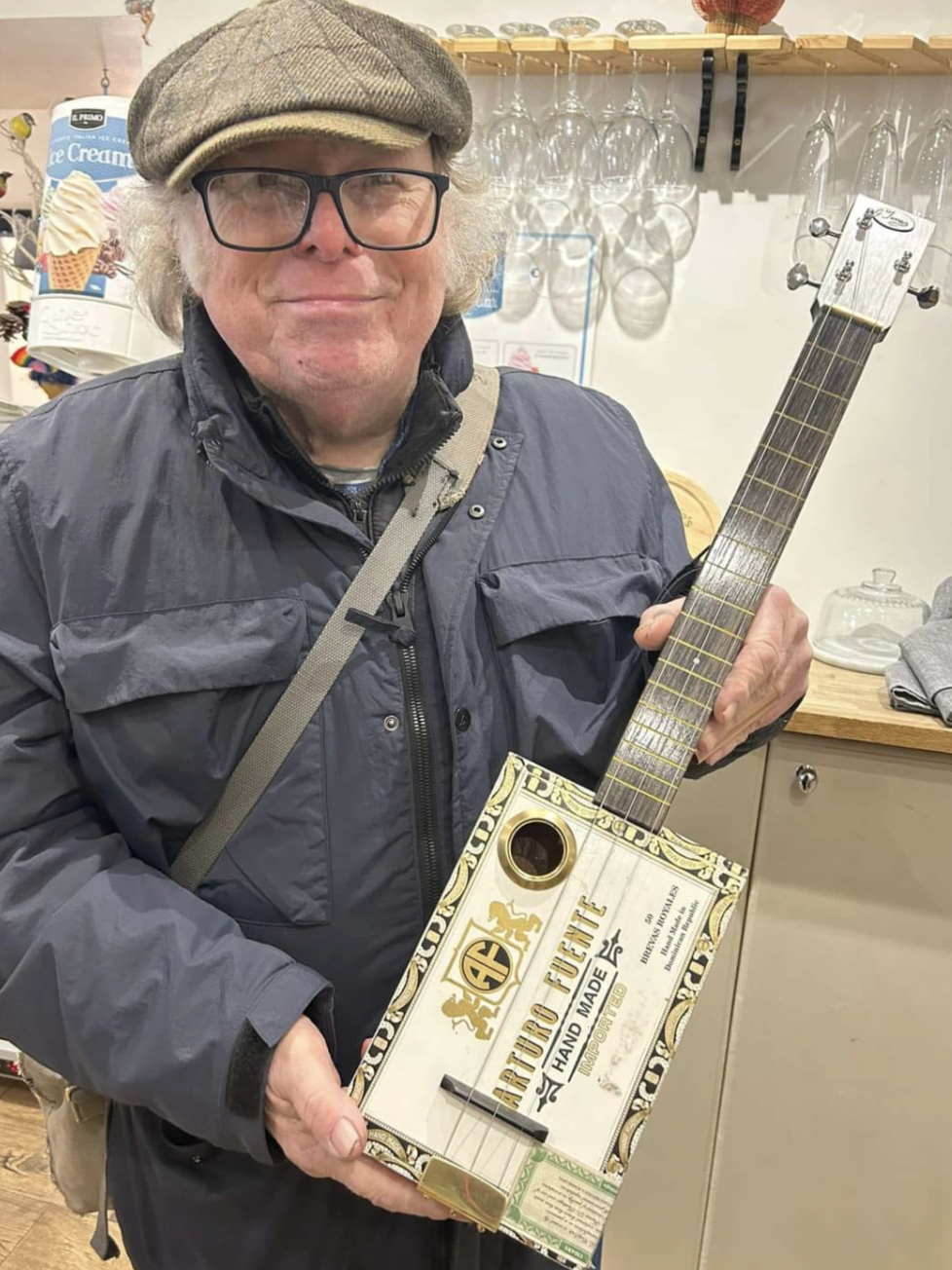 Gary Jones pictured with the cigar box guitar that he made