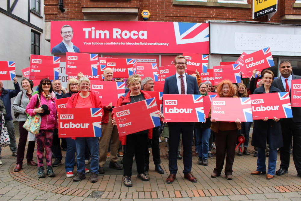 Labour candidate Tim Roca (suit, centre) outside their campaign HQ with supporters on Mill Street, Macclesfield. (Image - Macclesfield Nub News)