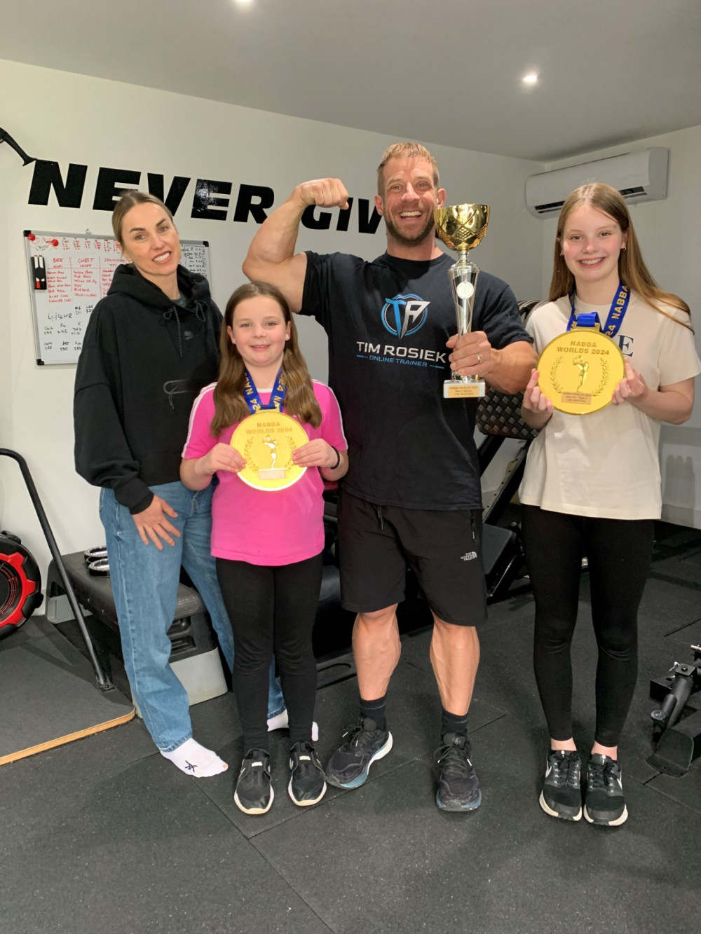 Nantwich strongman, Tim Rosiek, 41, with his family after being awarded NABBA world bodybuilding champion (Nub News).