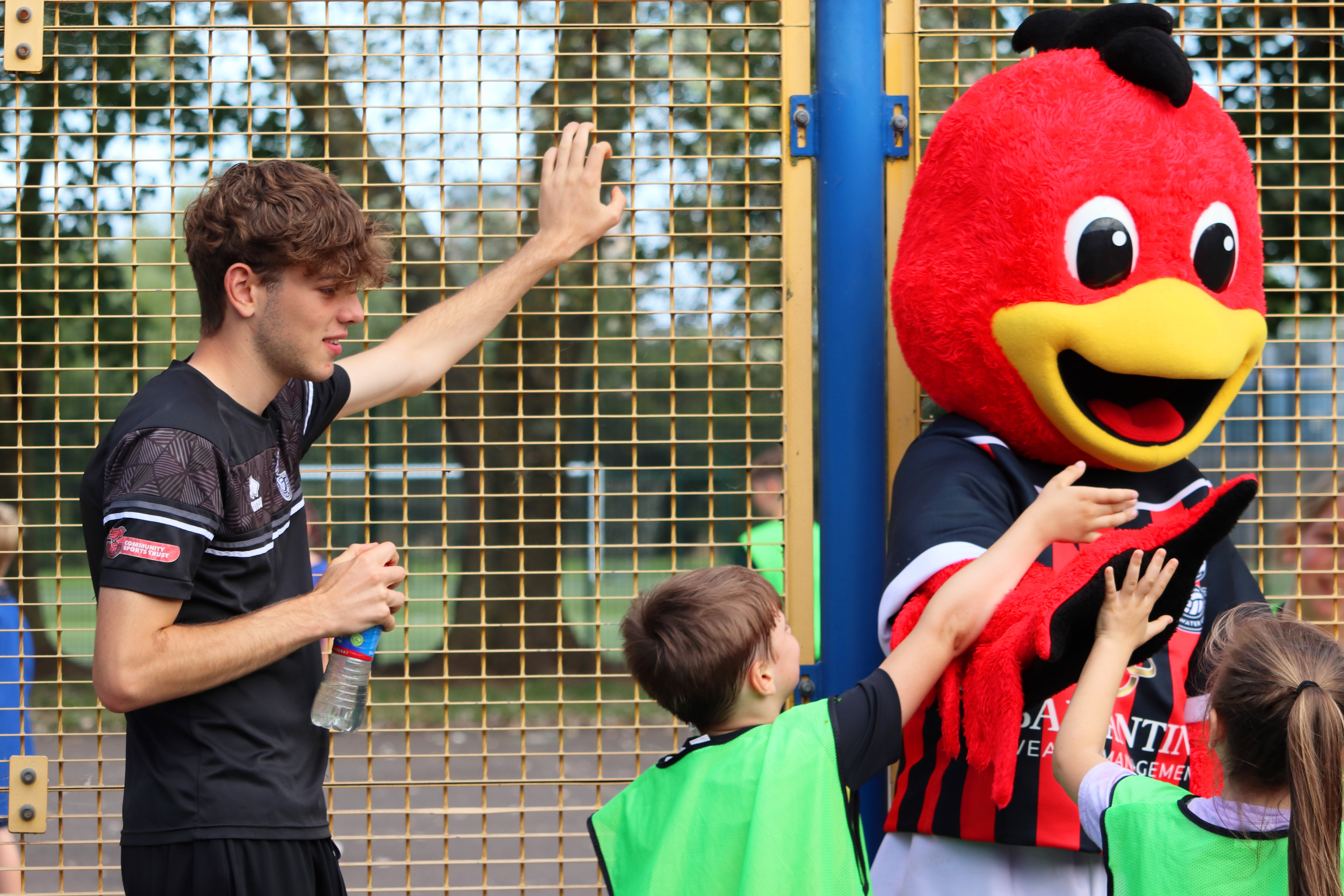 A young volunteer at Bridgwater United Community Sports Trust watches over some children as they meet the mascot