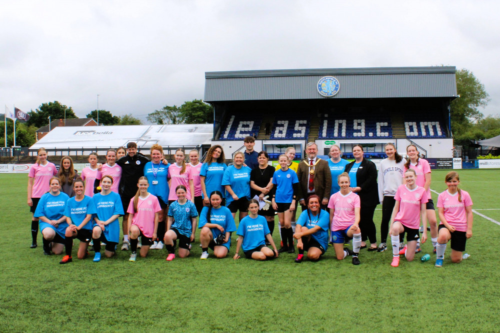 Teams from Carefound Home Care in Wilmslow (blue) and Macclesfield Ladies Football Club (pink) with the Mayor of Macclesfield Sandy Livingstone. 