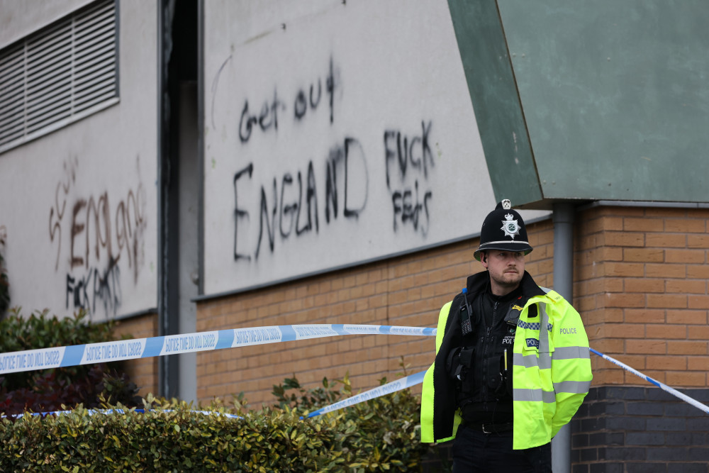 A police officer outside a hotel in Tamworth targeted by far-right protesters (image via SWNS)