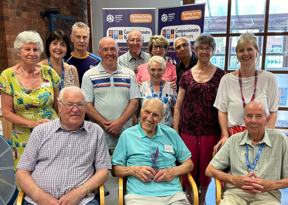 Compassionate Neighbours staff, volunteers and hub attendees with the trophy 