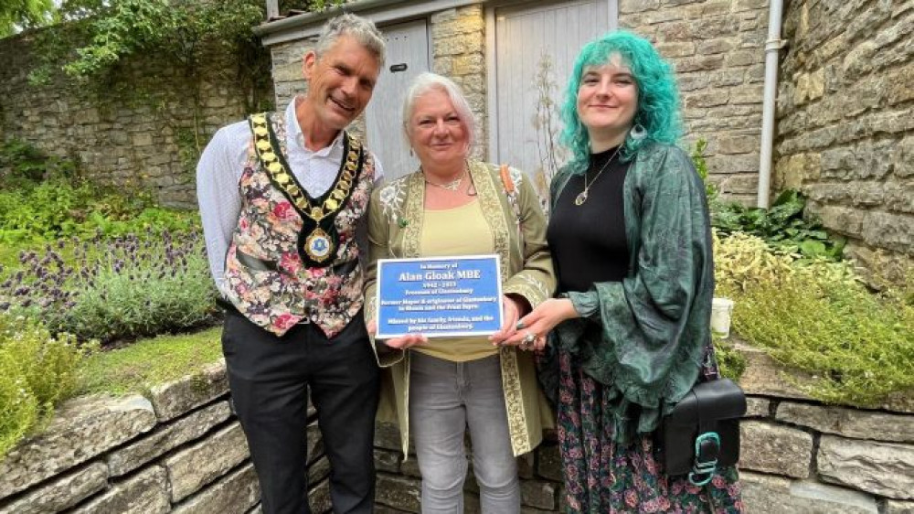 The Mayor of Glastonbury Cllr Lokabandhu with Alan’s niece Kim and her daughter Elise and the memorial plaque installed at the Town Hall for Alan Gloak. (GTC photo) 