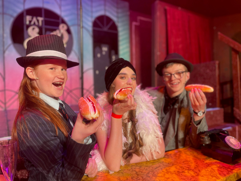 Holly Yuill (Fat Sam), Ruby Moloney-Ridsdale (Tallulah) and Jacob Butters (Bugsy Malone) with their Chatwins cream eclairs (Crewe Lyceum).