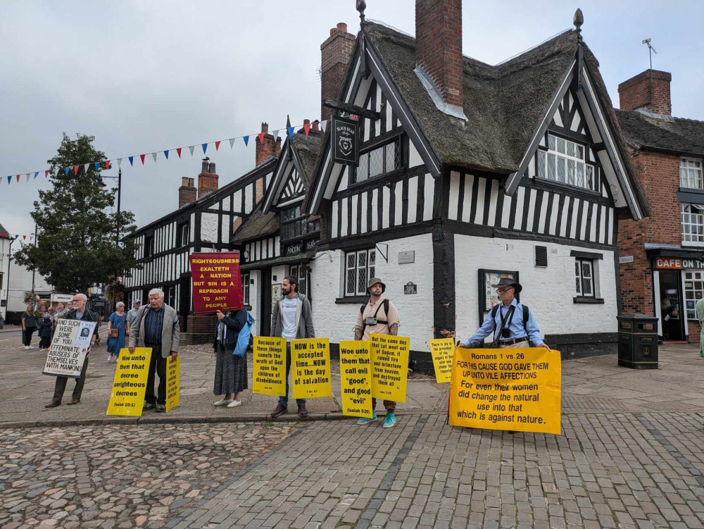 A small group of protesters carrying banners set up outside the Black Bear Lodge on Saturday. (Photo: Nub News) 