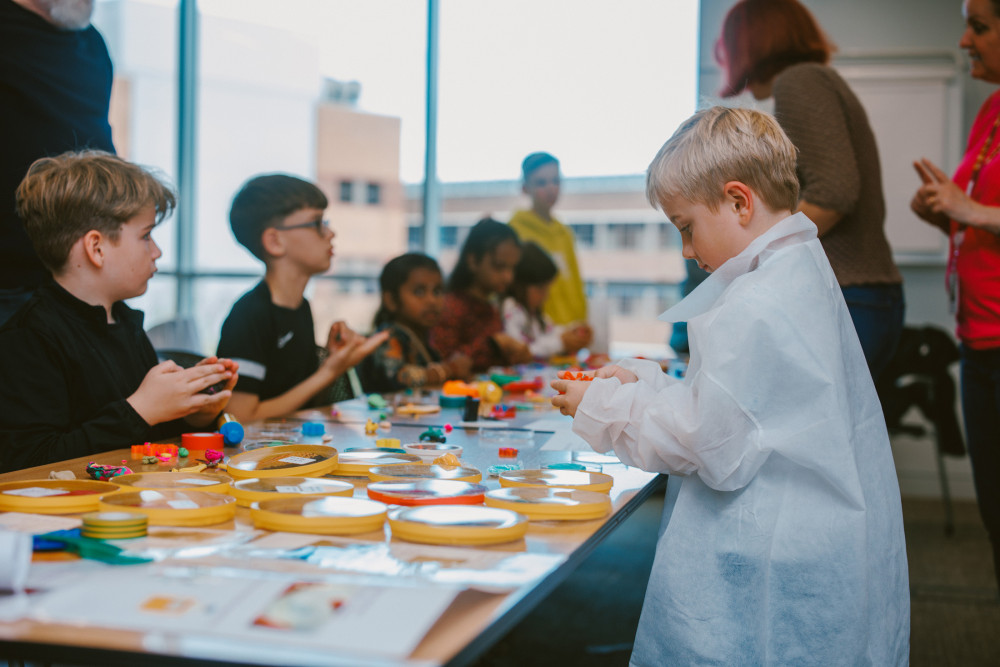 A child dons a mini lab coat at the recent AstraZeneca Fun Day. (Image - AstraZeneca)