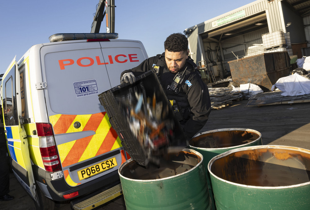 A police officer disposes of confiscated knives and machetes (Image - GMP)