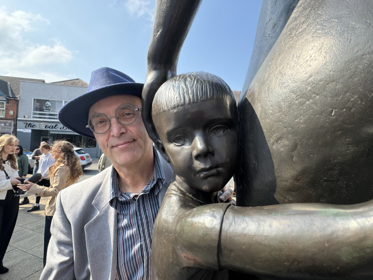 Dr Ceri Thomas, son of the statue's sculptor Robert Thomas, with the 'child' who was based on him. Photos: Coalville Nub News