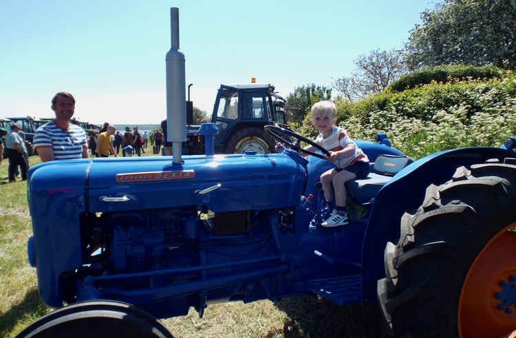 A tractor loving young boy gets the chance to be in the driving seat