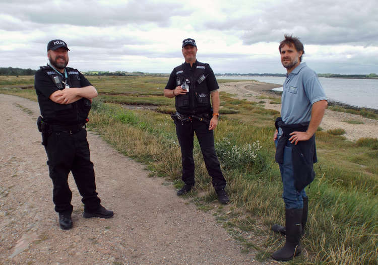 Rural crime team officers Paul Cantwell and Colin Taylor discussing plover campaign with AONB's nature recovery officer Alex Moore da Luz