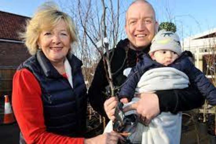 Environment portfolio holder for bio-diversity Liz Malvisi with dad and baby getting a Tree for Life