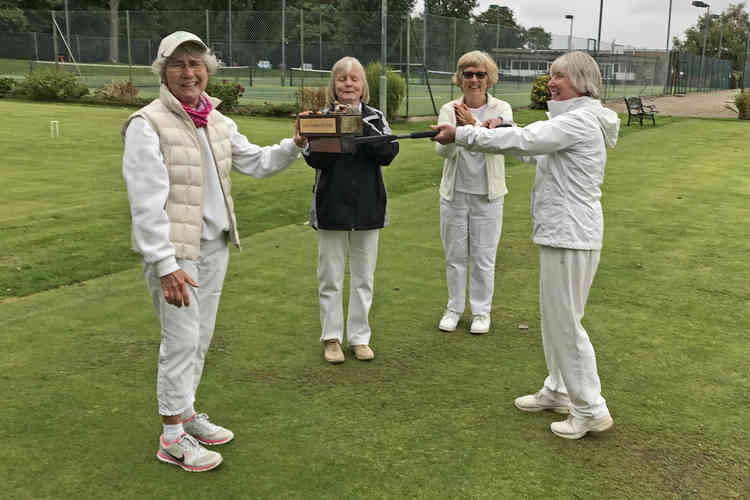 Pauline Harvey (right) presenting the trophy to Pauline Dennis using a mallet to respect Covid restrictions! Irene Rogers (left) and tournament manager Lynne Breedon can be seen in the background.