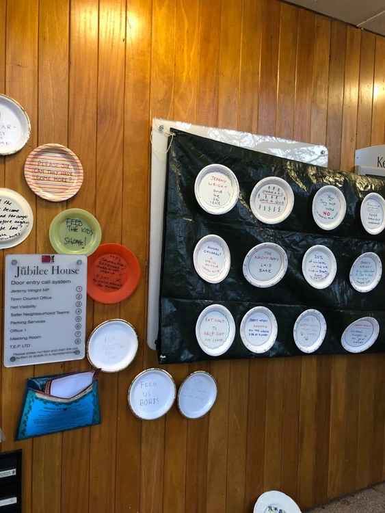 Demonstrators attached empty paper plates to the front wall of Mr Wright's Kenilworth office