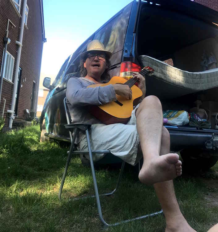 Neil bradley with his guitar and old van. Writing something for the Covid Concept Album?