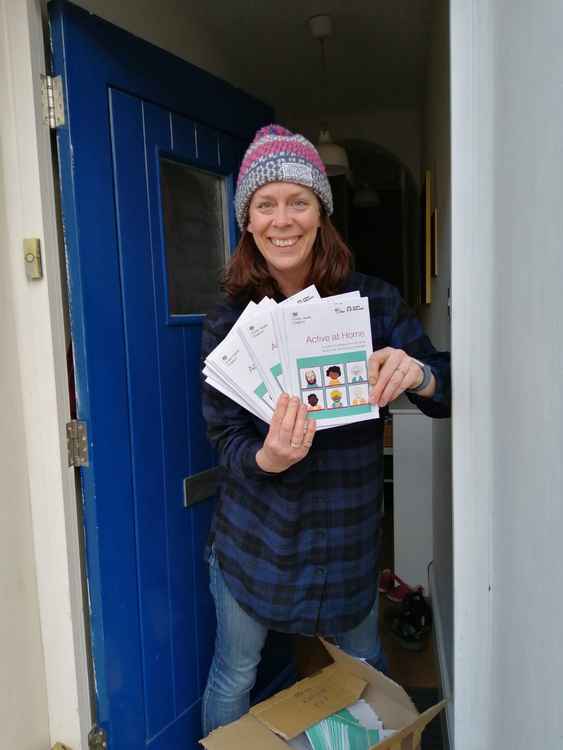 Volunteers Becky taking receipt of 'Get Active' brochures to deliver to residents