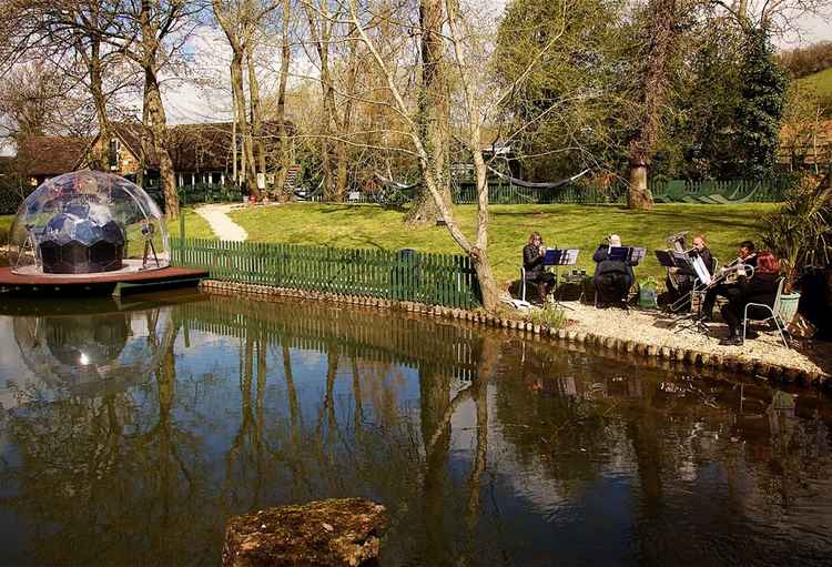 Royal Spa Brass Band assemble to by the duck pond to greet arriving guests