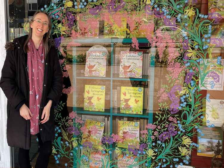 Julia Rawlinson standing next to her window display at Kenilworth Books