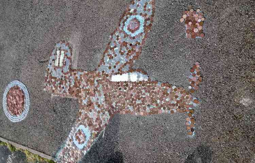 The outline of a Spitfire complete with coins collected on VE Day 75