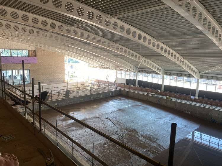 The roof swoops down over the swimming pools, which are dug and ready to be tiled