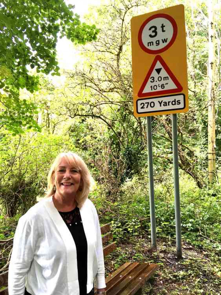 Cllr Karen Walker next to one of the new signs.