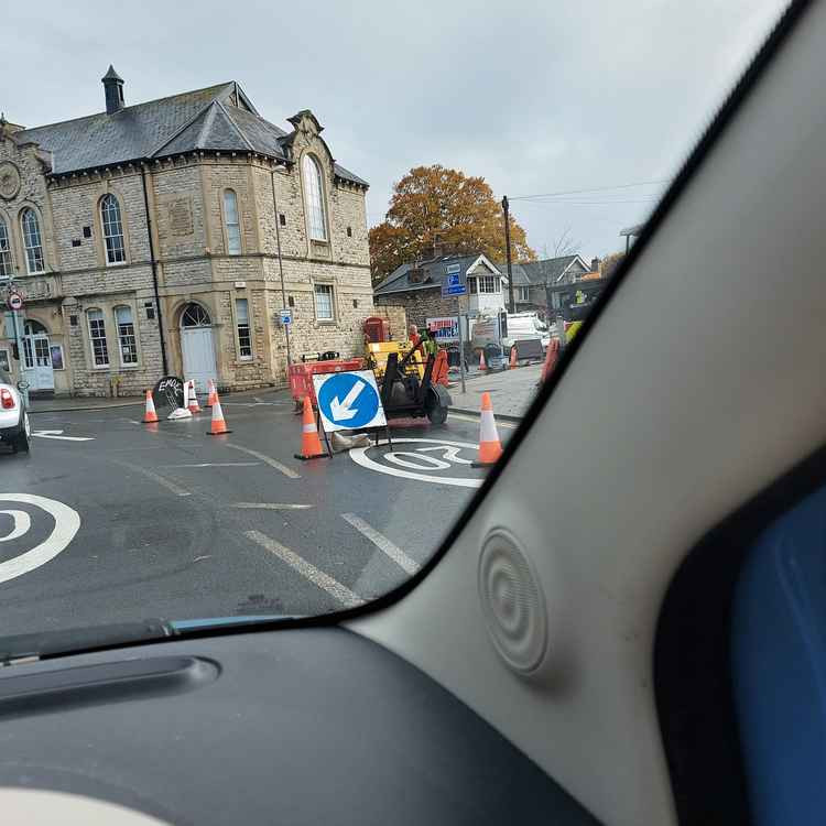 The three way traffic lights are just outside the library