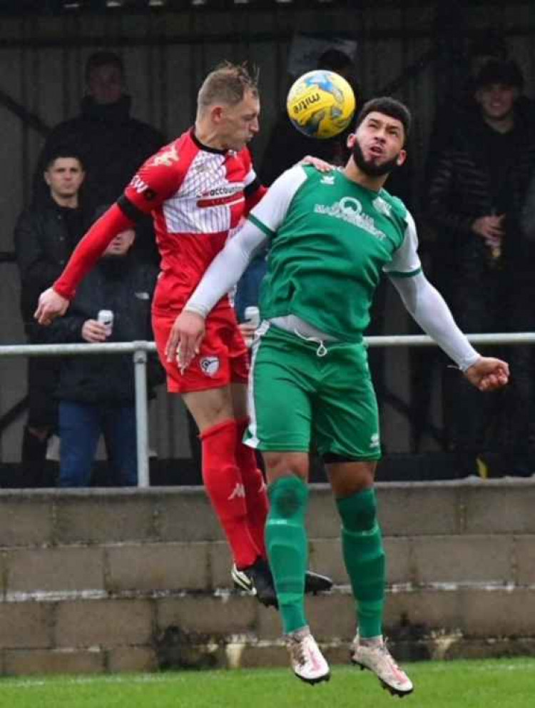 Radstock Town skipper Luke Ingram outjumps Courtney Charles in their 0-3 win over local rivals Welton Rovers at West Clewes; Photo by John Newport