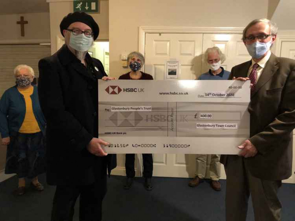 Cllr Jon Cousins hands £400 cheque to John Clare, chair of the Glastonbury People's Trust